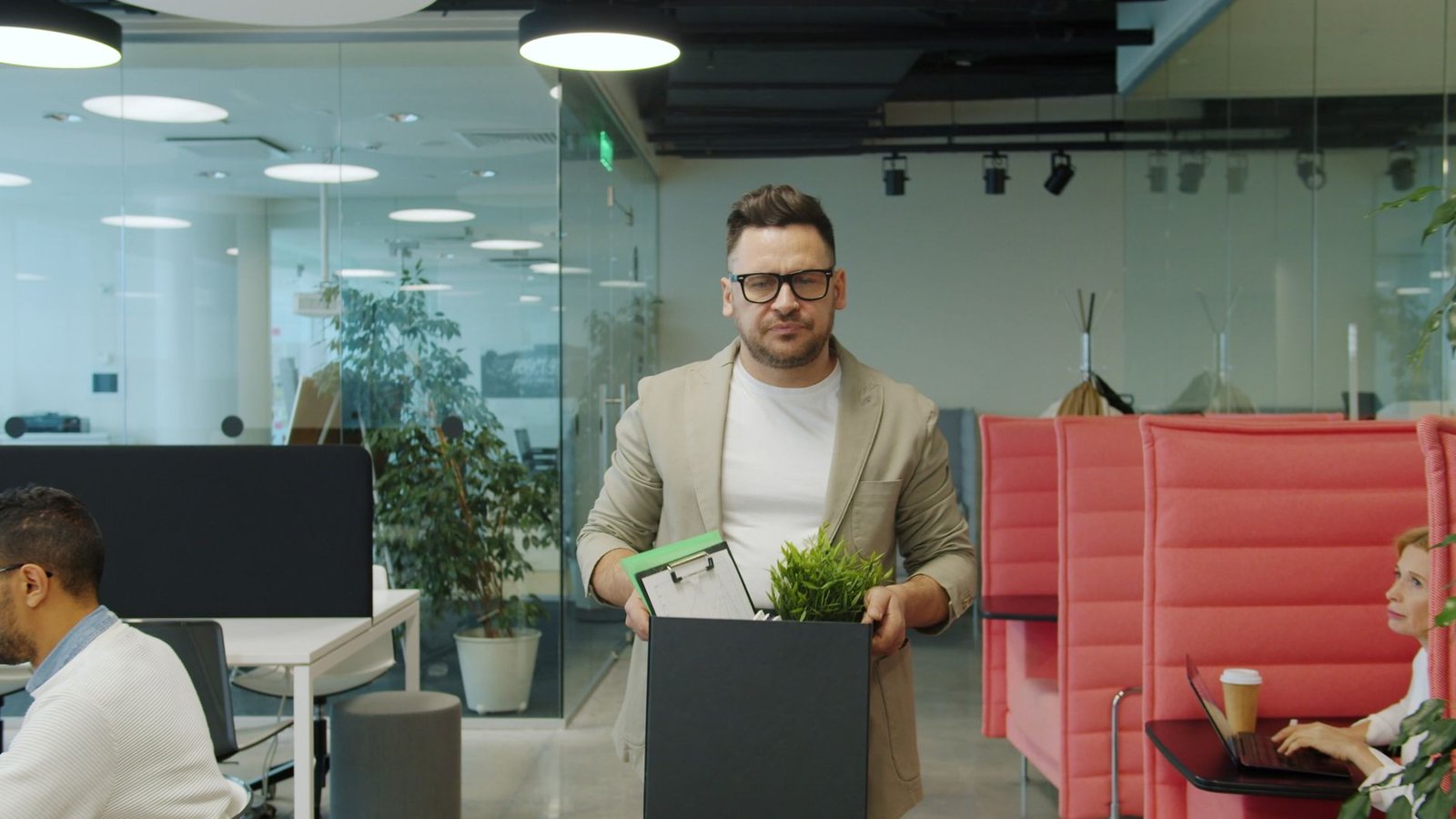Man carrying a box of belongings after leaving an office